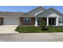 Charming brick home featuring an attached garage, well-manicured lawn, and inviting front porch at 2324 Harvest Moon Dr, Indianapolis, IN 46229