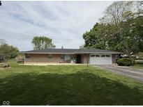 Charming single-story home featuring a brick facade, well-maintained lawn, and attached two-car garage at 2350 Brewer Dr, Indianapolis, IN 46227