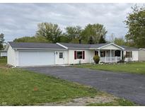 Charming single-story home with attached garage, long driveway, and inviting front porch at 3209 Pebblebrook Dr, Elwood, IN 46036