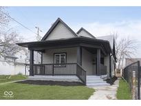Charming home featuring a covered front porch with black accents and landscaped yard at 3845 Cornelius Ave, Indianapolis, IN 46208