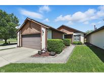 Charming home featuring a two-car garage and manicured landscaping, inviting curb appeal at 4107 Zinfandel Way, Indianapolis, IN 46254