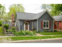 Charming bungalow with gray siding, brick chimney, well-manicured landscaping, and mature trees at 440 Linden St, Zionsville, IN 46077