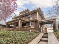 Charming two-story brick home featuring an attached covered area and landscaped front yard at 5181 E Pleasant Run Pkwy S Dr, Indianapolis, IN 46219
