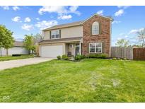 Charming two-story home featuring a well-manicured lawn and a combination of brick and siding exterior at 7163 Cordova Dr, Indianapolis, IN 46221