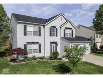 Charming two-story home featuring a well-maintained lawn, complemented by dark shutters and a two-car garage at 7202 Red Lake Ct, Indianapolis, IN 46217