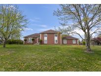 Expansive exterior view of a brick home with a well-manicured lawn and mature trees at 8031 Edgewood Ct, Plainfield, IN 46168