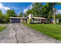 Charming single-story home with stone accents, a well-manicured lawn, and an attached two car garage at 845 W 77Th St S Dr, Indianapolis, IN 46260