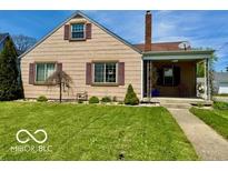 Charming single-Gathering home featuring a well-maintained lawn and a cozy front porch at 908 E 32Nd St, Anderson, IN 46016