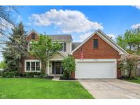 Charming two-story home featuring a brick facade, attached two-car garage, and a well-manicured front lawn at 10764 Gettysburg Pl, Carmel, IN 46032
