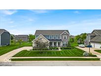 Beautiful two-story home with manicured lawn, stone accents and covered entry at 11438 Montoya Dr, Zionsville, IN 46077