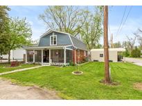 Charming home featuring a screened-in porch, well-maintained lawn, and convenient detached garage for parking at 116 High St, Brooklyn, IN 46111