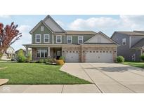 Charming two-story home with a brick and siding exterior, manicured lawn and an attached two-car garage at 16112 Lavina Ln, Fishers, IN 46040