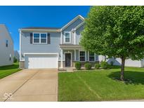 Charming two-story home featuring a manicured lawn, classic curb appeal, and an attached two-car garage at 2006 Creek Bank Dr, Columbus, IN 47201