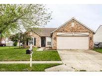 Charming single-story brick home with a well-manicured lawn and an attached two-car garage at 4303 Cowslip Ct, Indianapolis, IN 46203
