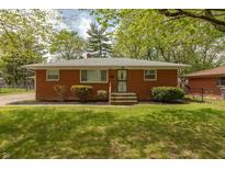 Charming brick home featuring a well-maintained lawn and mature trees under a sunny blue sky at 4468 N Elizabeth St, Indianapolis, IN 46226