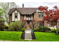 Charming brick two-story home with manicured lawn, lovely landscaping, and welcoming front steps at 5124 N Capitol Ave, Indianapolis, IN 46208