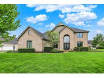 Brick home featuring mature landscaping, a large lawn and a basketball hoop on the side of the house at 5255 Apache Moon, Carmel, IN 46033