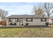 Charming one-story home featuring a brick facade, cozy front porch, and well-maintained landscaping at 617 Grovewood Dr, Beech Grove, IN 46107