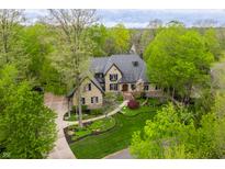 Stunning stone home with mature trees, lush landscaping, and a winding walkway at 9312 Sullivan Pl, Zionsville, IN 46077