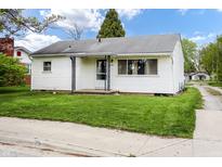 A well-maintained single-story home with white siding, green lawn, and mature trees in a quiet neighborhood at 1020 E Sixth St, Greenfield, IN 46140