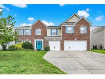 Charming two-story brick home with a well-manicured lawn, two-car garage, and a vibrant blue front door at 10828 Young Lake Dr, Indianapolis, IN 46229