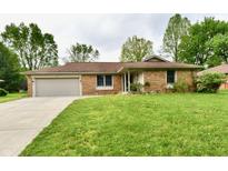 Charming brick ranch home with attached garage and a well-maintained lawn at 135 Hickory Ct, Greenwood, IN 46142