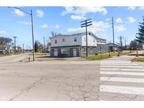 Two story commercial building with a gray and white exterior, garage doors and manicured landscaping at 1630 N Granville N Ave, Muncie, IN 47303