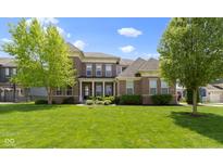 Charming two-story brick home featuring a well-manicured lawn, inviting front porch and beautiful landscaping at 16305 Kenora N Ln, Fortville, IN 46040