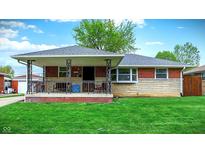 Charming single-story brick home featuring a cozy front porch and well-maintained lawn at 1964 Mann Dr, Beech Grove, IN 46107