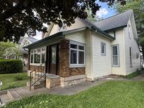 Quaint bungalow with vinyl siding, updated windows, and a well-maintained lawn at 2119 S Garfield Dr, Indianapolis, IN 46203