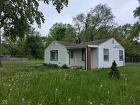 Quaint single-story home featuring white siding, a brick chimney, and a small front porch at 2315 E 3Rd St, Anderson, IN 46012
