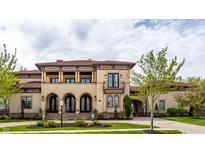 Elegant two-story home with a tiled roof, arched entryways, a balcony, and manicured landscaping at 2377 Finchley Rd, Carmel, IN 46032