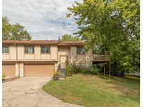Inviting two-story townhome featuring a large front yard, attached garage, and exterior stone and wood accents at 3131 Stillmeadow Dr, Indianapolis, IN 46214
