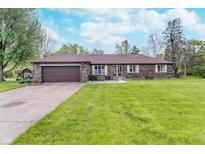 Charming brick ranch home with a well-manicured lawn and attached two-car garage at 417 W Ash St, Jamestown, IN 46147