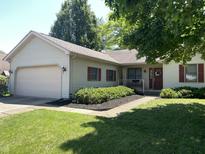 Charming one story home with a well-maintained front yard and an attached two car garage at 4611 29Th St, Columbus, IN 47203