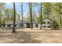 Charming front exterior of a two-story home with black and white paint and mature trees at 5190 Potters Pike, Indianapolis, IN 46234
