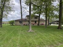 Charming home with stone accents and a well-manicured lawn, surrounded by mature trees at 5282 W Blue Bell Dr, New Palestine, IN 46163