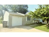 Charming home featuring an attached garage, well-manicured lawn, and inviting front porch at 5415 Wagon Wheel Trl, Indianapolis, IN 46237