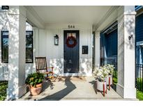 Inviting front porch with rocking chair, potted plants, and stylish front door with wreath at 544 N Beville Ave, Indianapolis, IN 46201