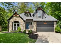 Charming home featuring stone accents, gray siding, and a well-manicured front yard at 5548 Painted Maple Ct, Indianapolis, IN 46254