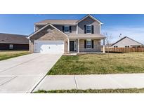 Two-story home with brick and gray siding, a two-car garage, and a well-manicured front lawn at 6559 Ambrosia Ln, Pendleton, IN 46064