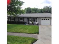 Charming single-story home featuring a well-maintained lawn and an attached one car garage at 8136 E 37Th Pl, Indianapolis, IN 46226