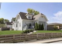 Charming white brick home with a manicured lawn and a cozy front porch for relaxing at 825 Iowa St, Indianapolis, IN 46203