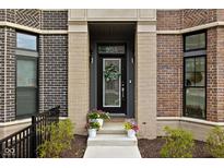 Charming front door with brickwork, transom window, and decorative floral wreath, creating a welcoming entrance at 904 Veterans Way, Carmel, IN 46032
