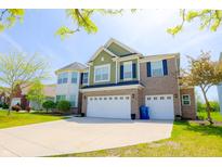 Inviting two-story home featuring a brick and siding exterior, a two-car garage, and a well-maintained front yard at 9993 Pepper Tree Ln, Noblesville, IN 46060