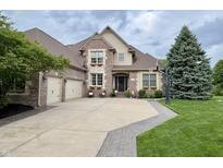 Beautiful brick home featuring a three-car garage, well-manicured lawn, and tasteful landscaping at 1014 Massey Ct, Greenwood, IN 46143