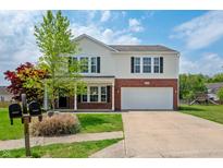 Charming two-story home with a well-maintained lawn, brick accents and an attached two-car garage at 10625 Gathering Dr, Indianapolis, IN 46259