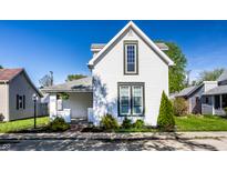 Charming two-story home featuring white siding, well-manicured lawn, and an inviting front garden at 139 N East St, Pendleton, IN 46064