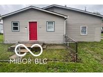 Charming single-story home features a red door and fenced front yard at 1710 S Birch St, Muncie, IN 47302
