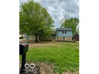 Charming home with two-tone siding, stone accents, covered porch, and lush green front yard at 1945 Plantation Ln, Martinsville, IN 46151